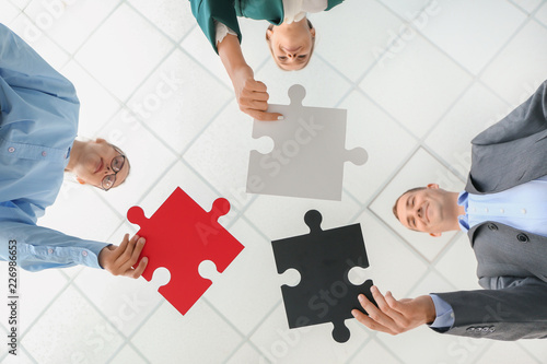Canvas Print Business team with pieces of puzzle in office, bottom view