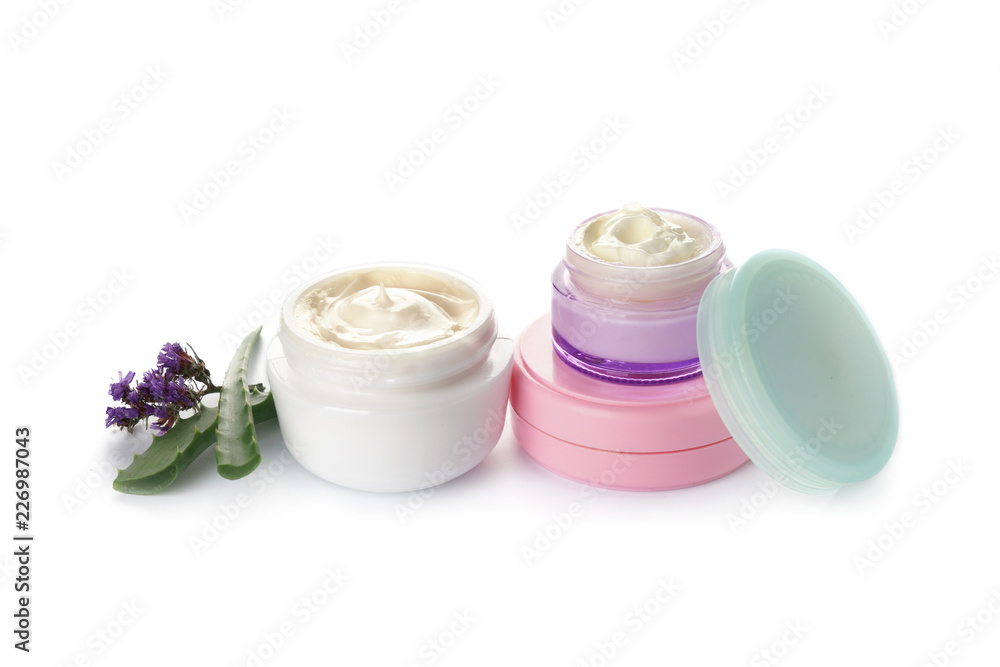 Jars of body cream with aloe vera and flowers on white background Jars of body cream with aloe vera and flowers on white background