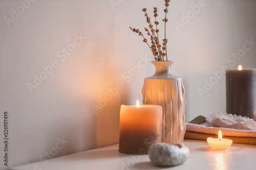 Beautiful burning candles with vase on table indoors
