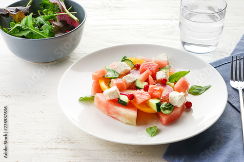 Plate with delicious watermelon salad on white table