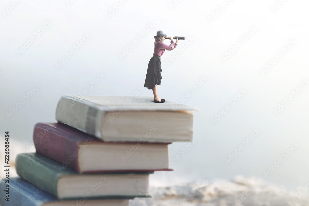 miniature woman looks at the infinity with the spyglass on a scale of books miniature woman looks at the infinity with the spyglass on a scale of books