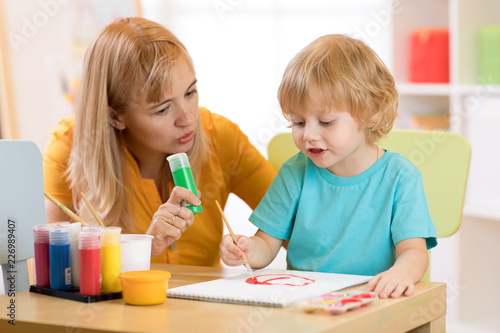 Child with teacher draw pai...