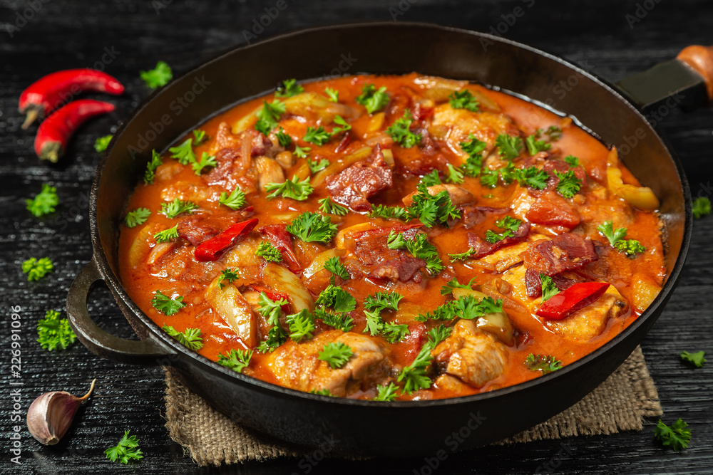 Chicken chilindron with thick vegetable sauce with red wine and dry-cured ham. Chicken chilindron with thick vegetable sauce with red wine and dry-cured ham.