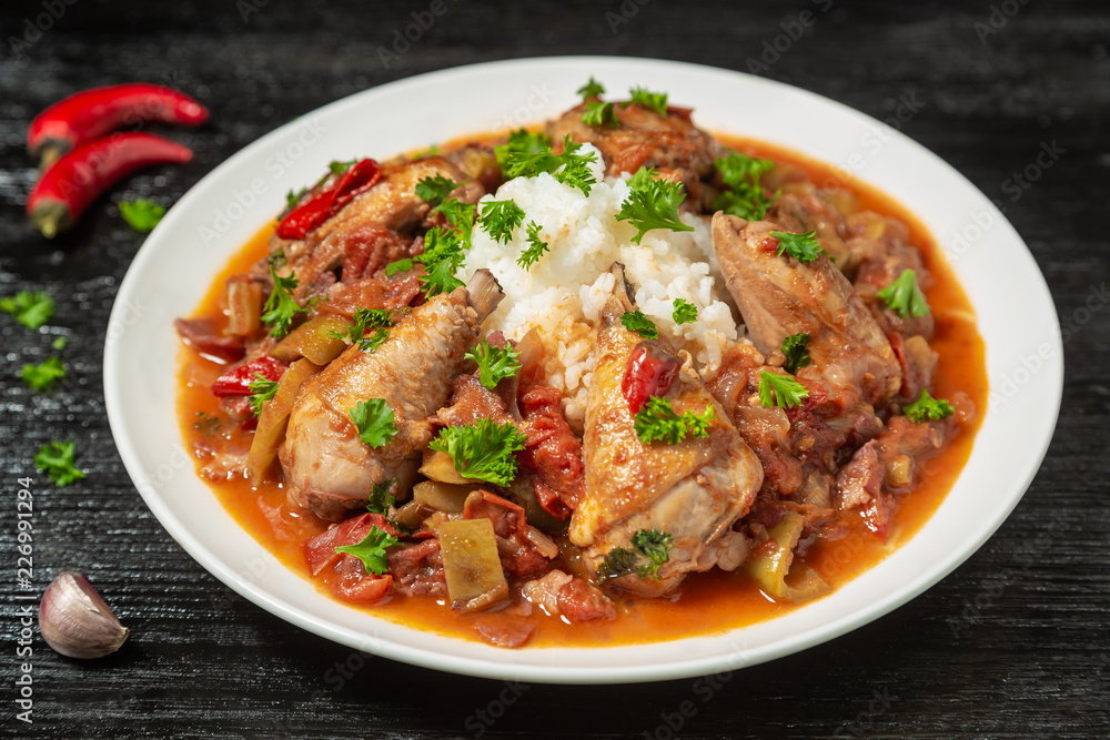 Chicken chilindron with thick vegetable sauce with red wine and dry-cured ham. Chicken chilindron with thick vegetable sauce with red wine and dry-cured ham.