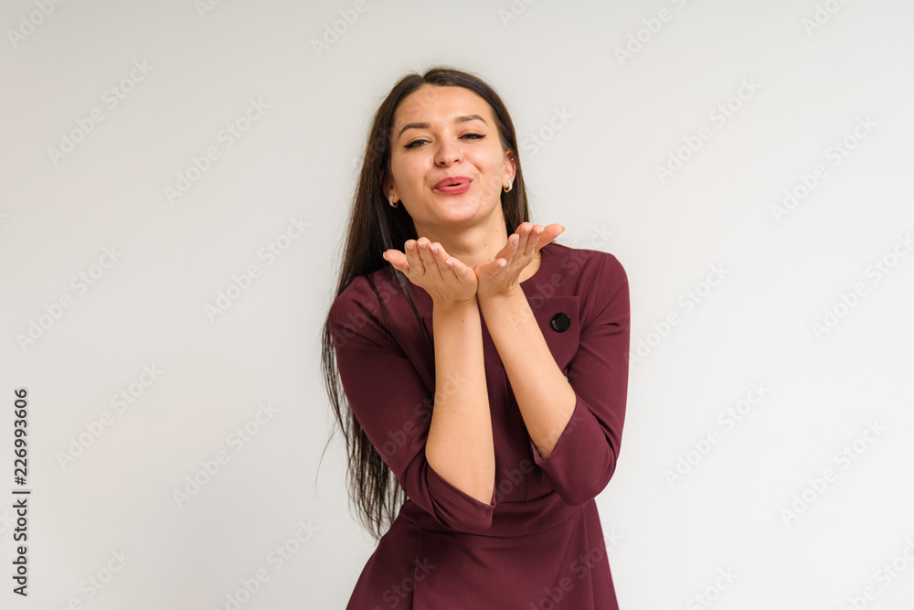 Studio portrait of a beautiful brunette girl on a white background with different emotions. Studio portrait of a beautiful brunette girl on a white background with different emotions.