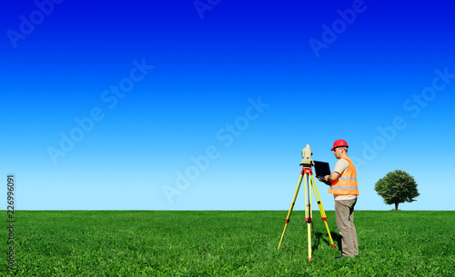 Surveyor on green field