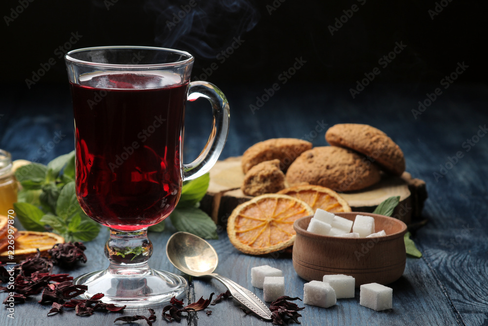 Hot red karkade tea with honey and biscuits. autumn. winter. on blue wooden table Hot red karkade tea with honey and biscuits. autumn. winter. on blue wooden table