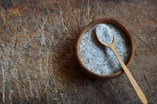Ayurvedic herbal salt in wooden spoon. Sea salt with aromatic herb - rosemary, oregano, sage, marjoram, basil, thyme, mint, bay leaf. Copy space