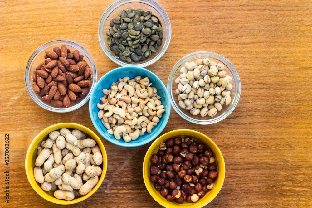 Assortment of mixed nuts on wood table background 