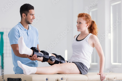 Foto Young woman wearing a brace during rehabilitation with her physiotherapist