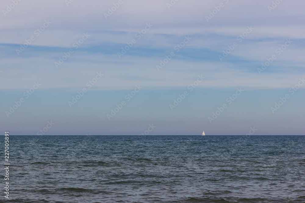 A white jacht boat on the horizon in the mediterranean sea