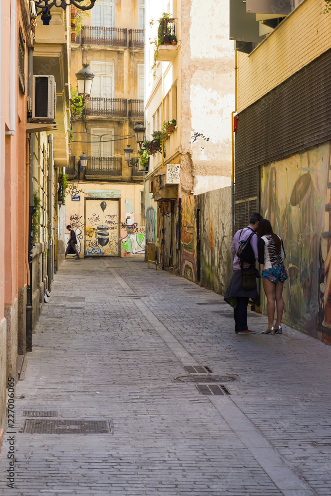 Valencia narrow street with couple of people guy and girl urban photo
