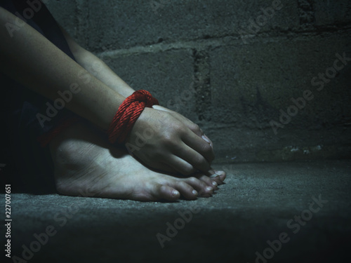 Kidnapped little girl tied with rope.Abused and tortured concept. Human trafficking concept. Stop violence against Women. International women's Day. Stop abusing violence.