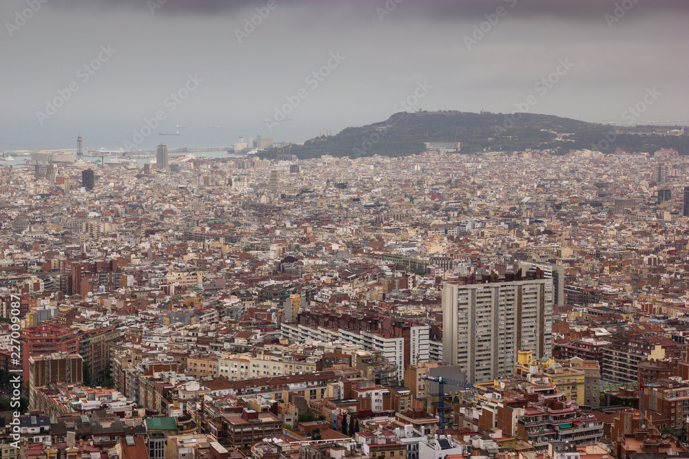 Fototapeta premium Cloudy view on Barcelona city from the mountain