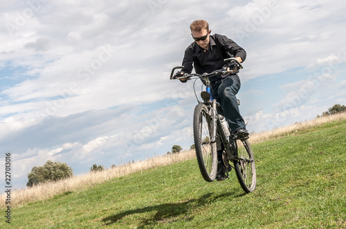 Man riding a bicycle in nature blue sky