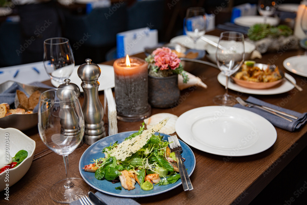 Salad shown close-up, in the background a dining room of a restaurant Salad shown close-up, in the background a dining room of a restaurant