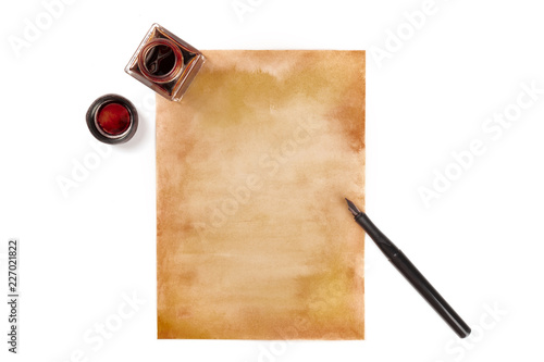 An overhead photo of an ink well with a piece of old paper and an ink pen, shot from above on a white background with copy space photo