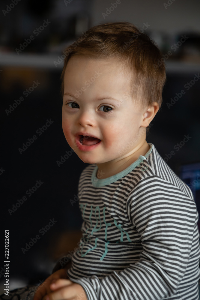 Portrait of cute small boy with Down syndrome in home living room Portrait of cute small boy with Down syndrome in home living room