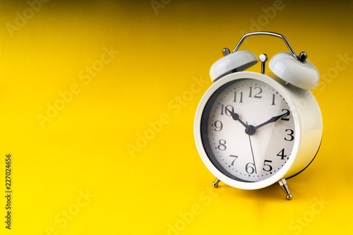 Clock on yellow background with selective focus and crop fragment. Copy space concept