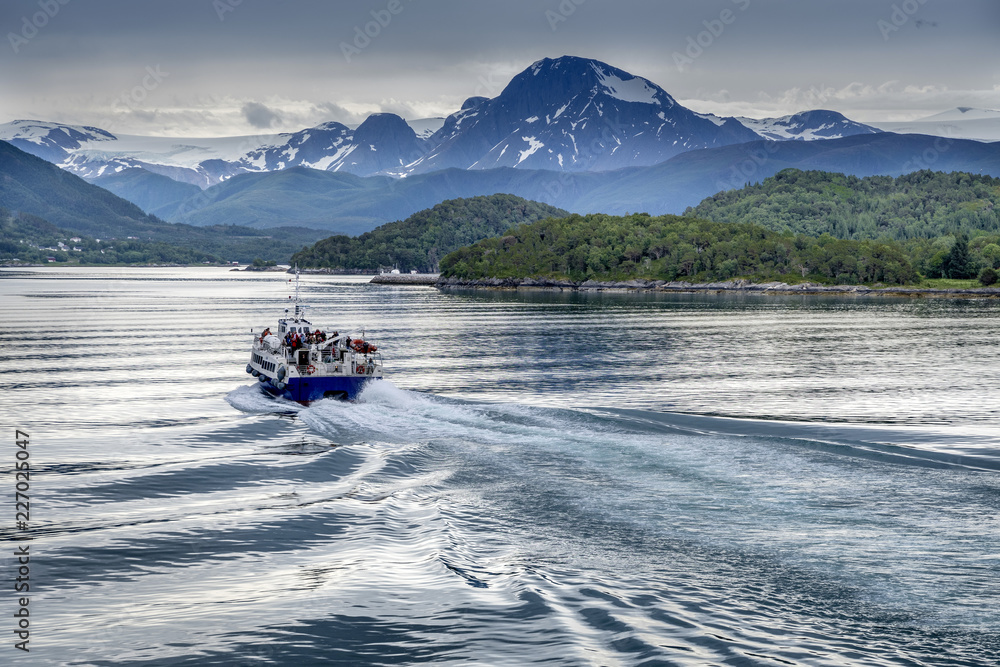 Blick von einem Schiff der Hurtigruten, der MS Polarlys, auf ein Expeditionsboot bei der Einfahrt in einen Fjord