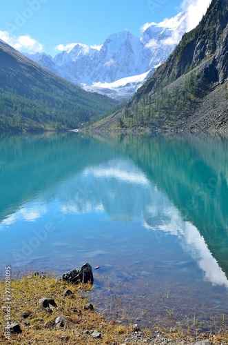 The reflection of the mountains Skazka and Krasavitsa (Tale and Beautiful) in a Large Shavlinskoye lake in sunny day, Altai mountains, Russia photo