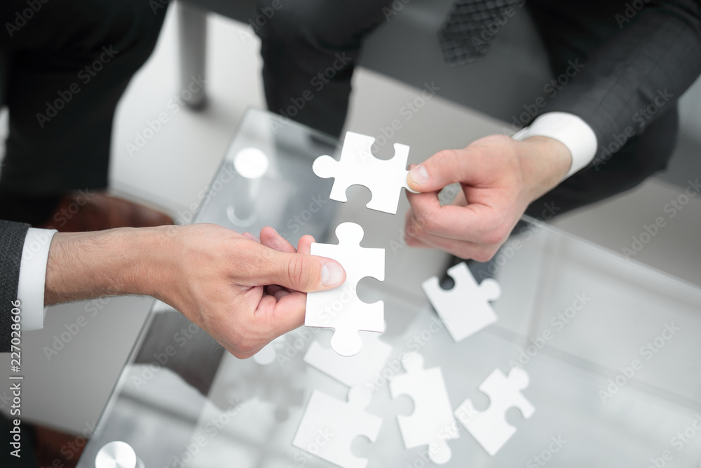 close up.business partners hold the puzzle pieces close up.business partners hold the puzzle pieces