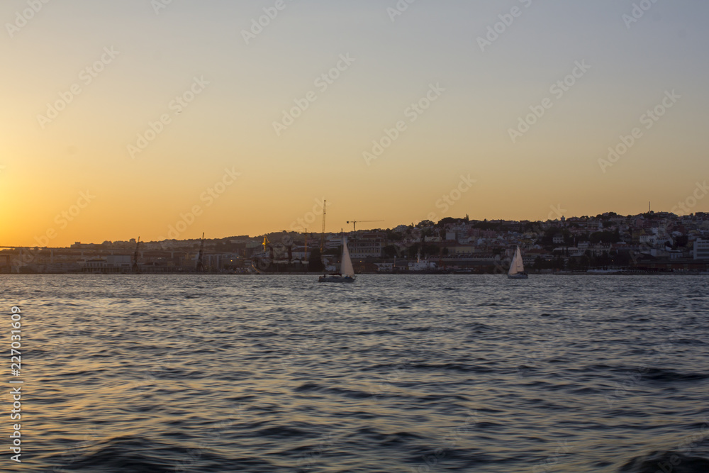 Sailboats on river at sunset