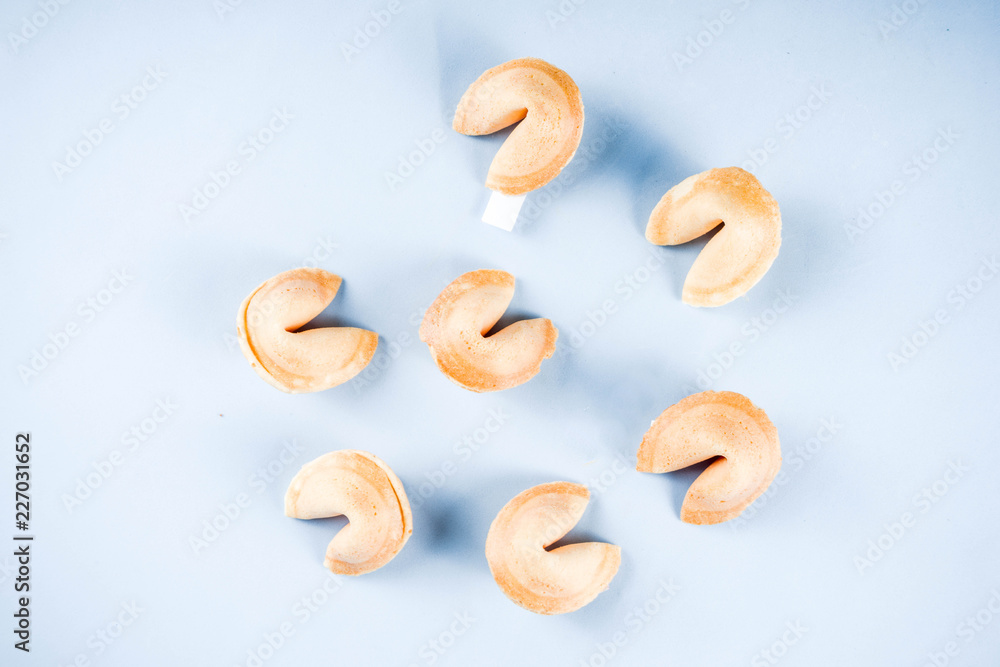 Chinese fortune cookie with prediction on light blue background top view copy space Chinese fortune cookie with prediction on light blue background top view copy space