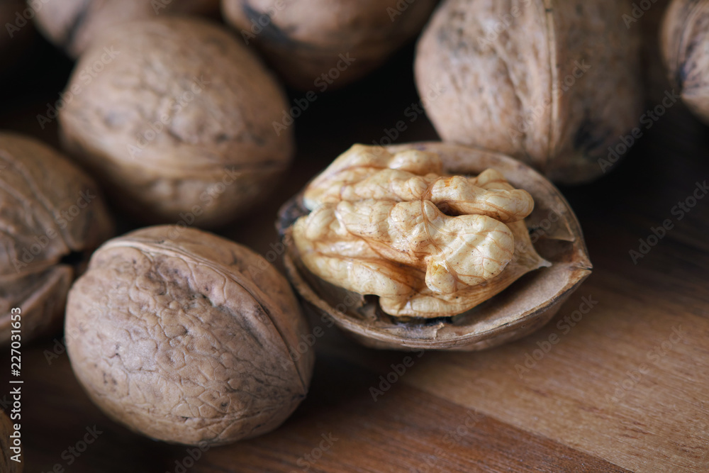 Closeup of whole and kernel walnuts on wooden background
