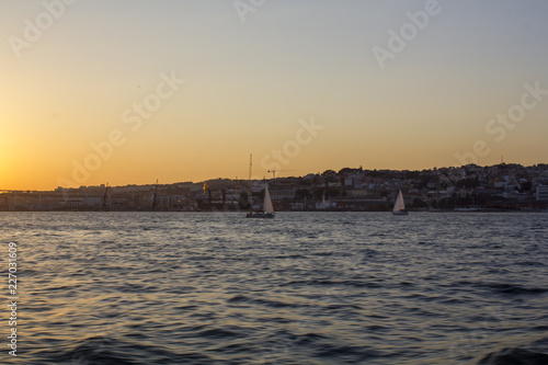 Sailboats on river at sunset
