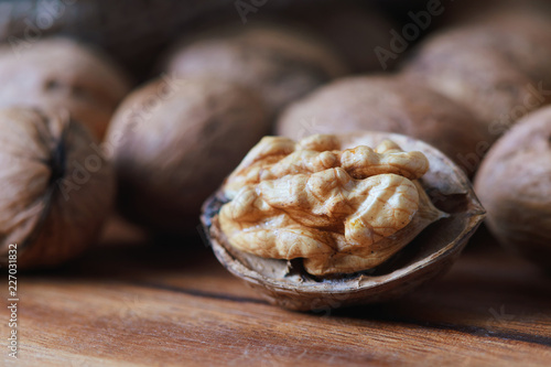 Closeup of whole and kernel walnuts on wooden background