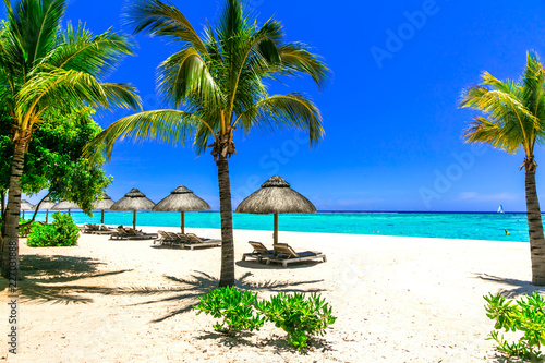 relaxing tropical holidays - beach chairs and umbrellas in white sandy beach of Mauritius island