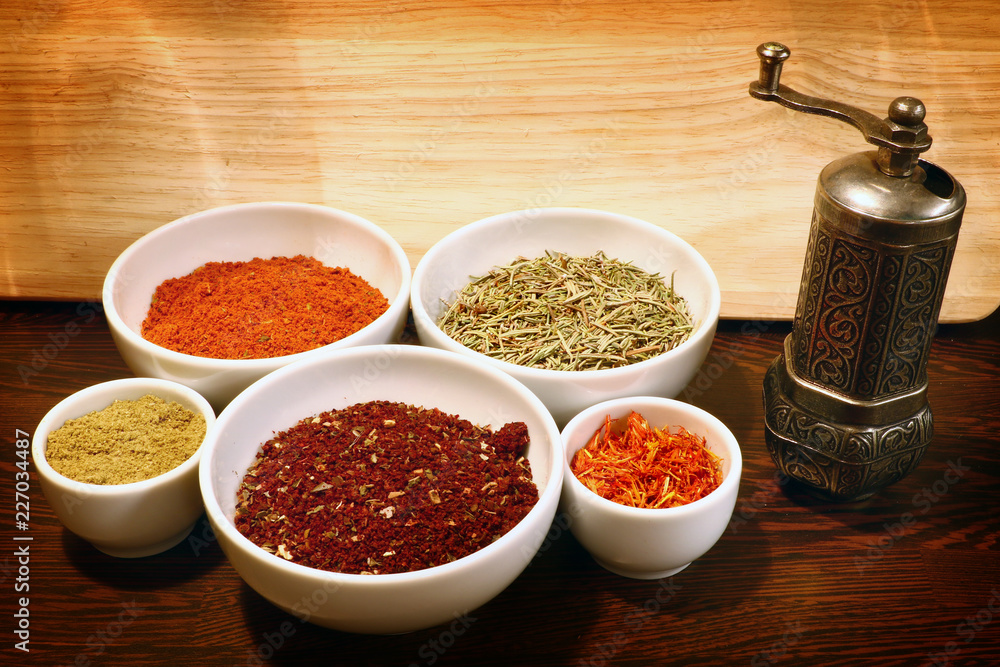different spices in a white ceramic cup and mill for spices, isolated different spices in a white ceramic cup and mill for spices, isolated