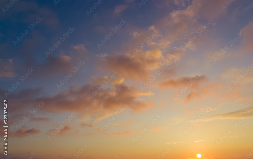 Beautiful sunset, clouds in soft pastel tones over horizon.