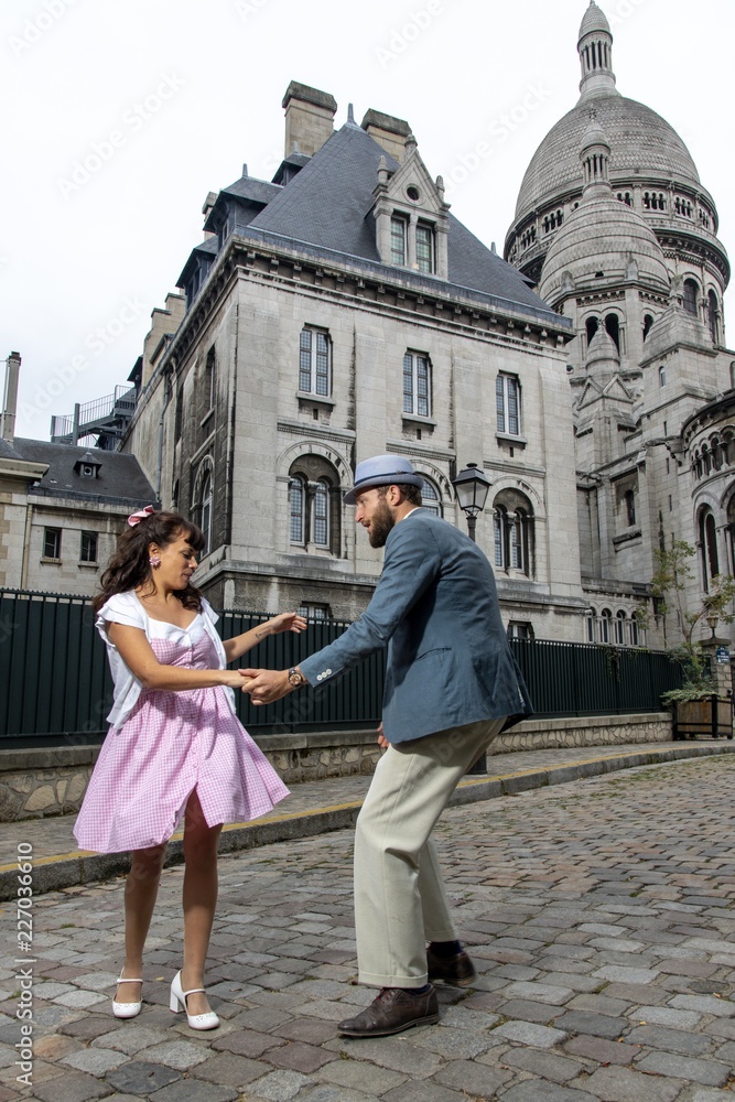 A couple of lovers dressed retro style dancing  in the streets of Montmartre, Paris, France