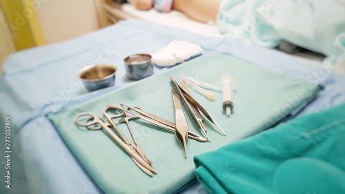 Surgical equipments  scissors  forceps and syringe on green hygiene cloth prepares for surgery or operation for accidental patient.