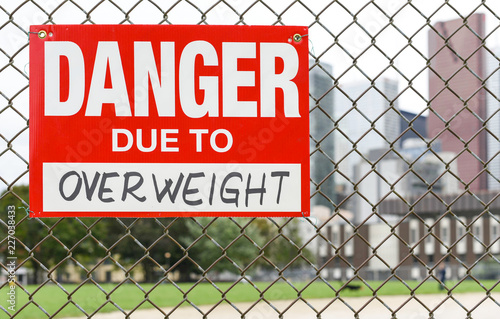  Sign danger due to overweight hanging on the fence