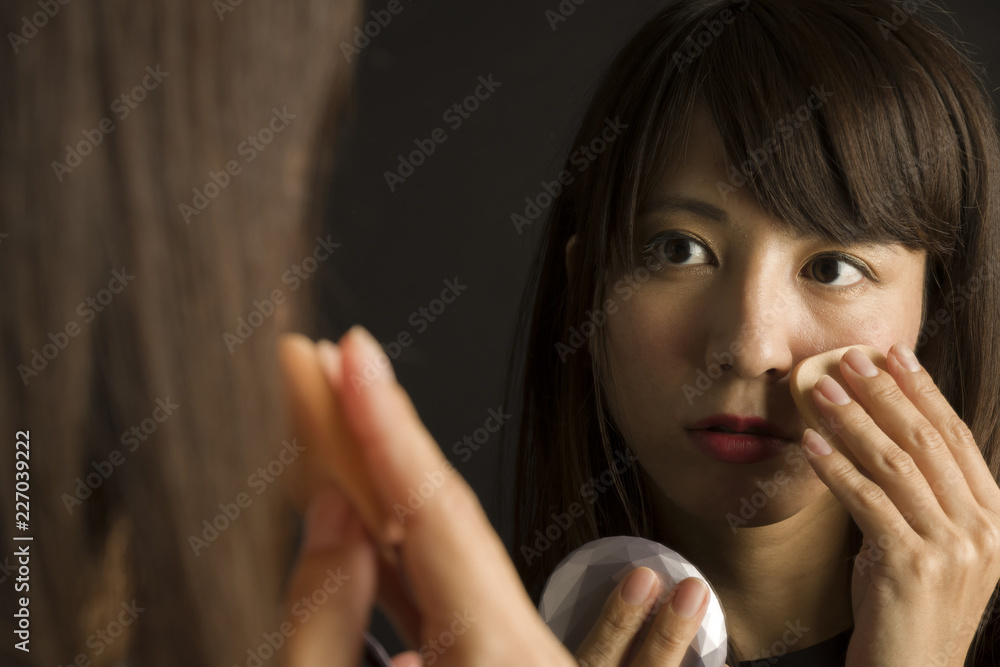 鏡に映った化粧する女性 鏡に映った化粧する女性