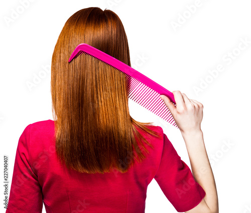 Redhead girl with big comb on white background
