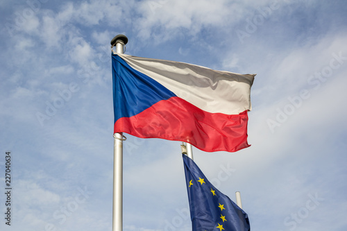 National flag of the Czech Republic and European union. Symbol of country, state, nation and EU are waving on the pole. Blue skywith cloud in the background