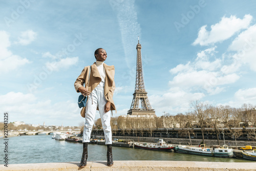 France, Paris, Smiling woman standing on a bridge with the Eiffel tower in the background © Westend61