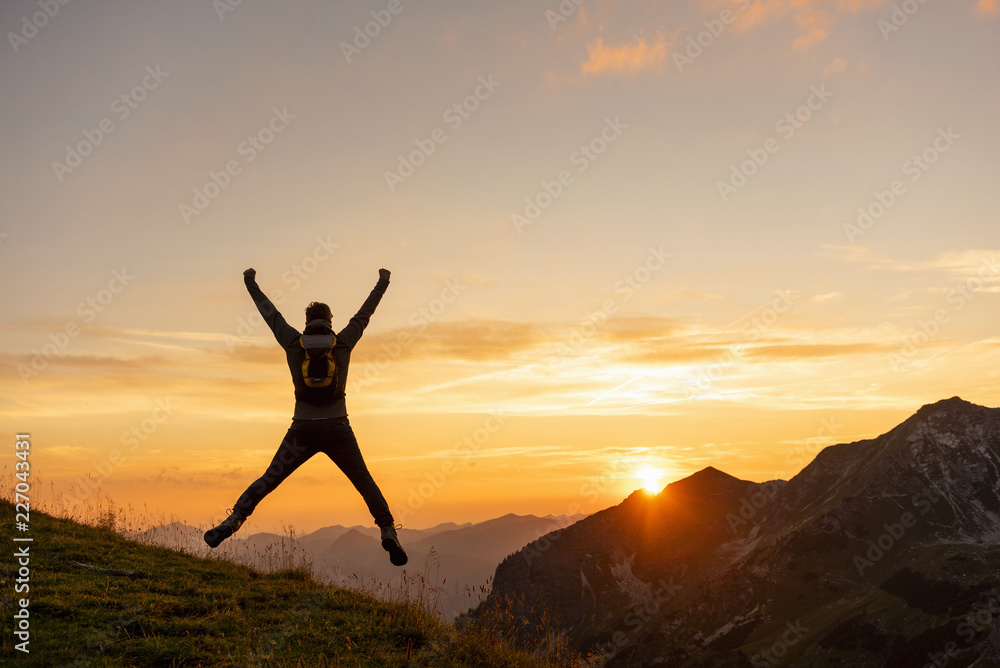 Germany, Bavaria, Oberstdorf, man on a hike in the mountains jumping at sunset Germany, Bavaria, Oberstdorf, man on a hike in the mountains jumping at sunset