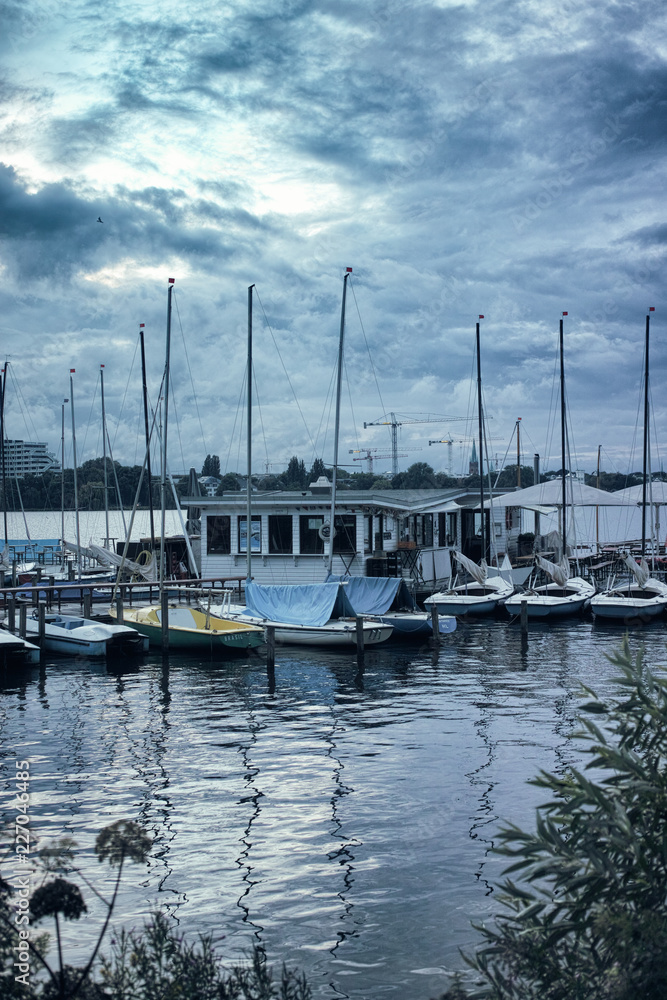 Small sailing boats on the Alster in Hamburg dramatic sky pedalo morning