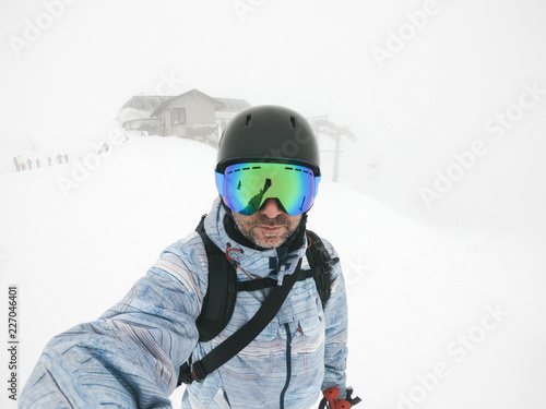 Italy, Modena, Cimone, portrait of man wearing ski goggles and helmet in haze photo