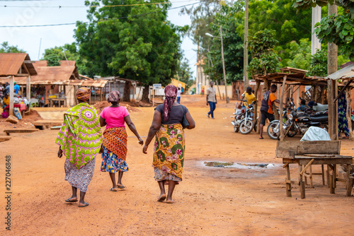 Togoville village in Togo. Women walking in African outfits in the village. Voodoo religion in Togo, West Africa. Togoville and Lomé voodoo markets.