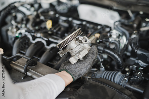 Hand of car mechanic with spare parts at service center repair