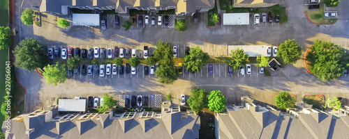 Panorama aerial view of apartment garage with full of covered parking, cars and green trees of multi-floor residential buildings in Houston, Texas, US. Urban infrastructure, transportation concept