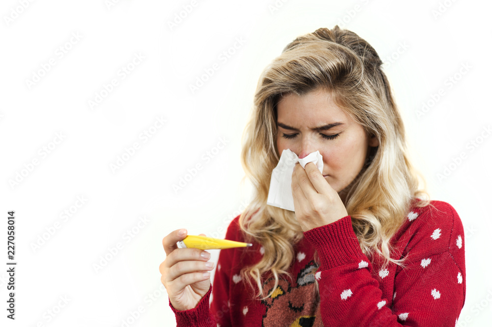 Symptoms of flu or allergies. Strong young European woman with fever, sneezing in a tissue, allergy, cold, with copy space, young girl, portrait of a sick woman, isolated on a white background. Symptoms of flu or allergies. Strong young European woman with fever, sneezing in a tissue, allergy, cold, with copy space, young girl, portrait of a sick woman, isolated on a white background.
