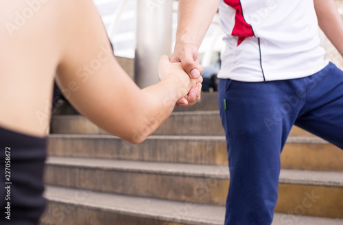 Close up image of attractive sport couple shaking hands,People handshake standing outdoors,Sportsmanship