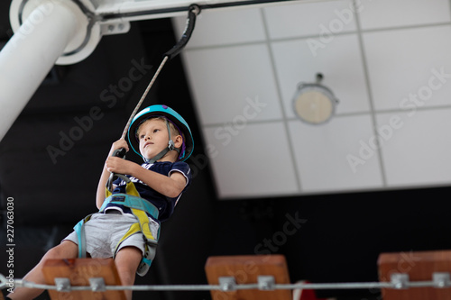 Young child crossing a bridge at the high rope course